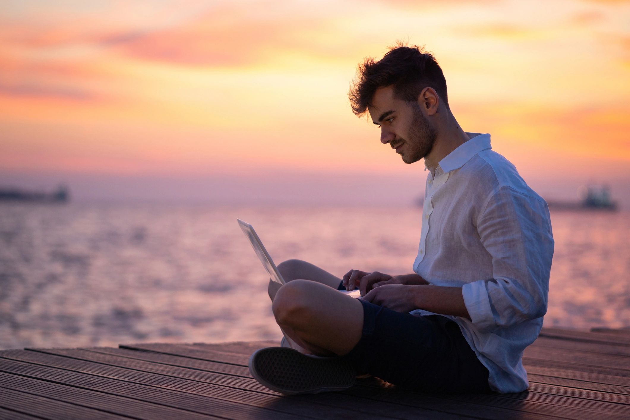 Outdoor content creator working on a laptop by the water