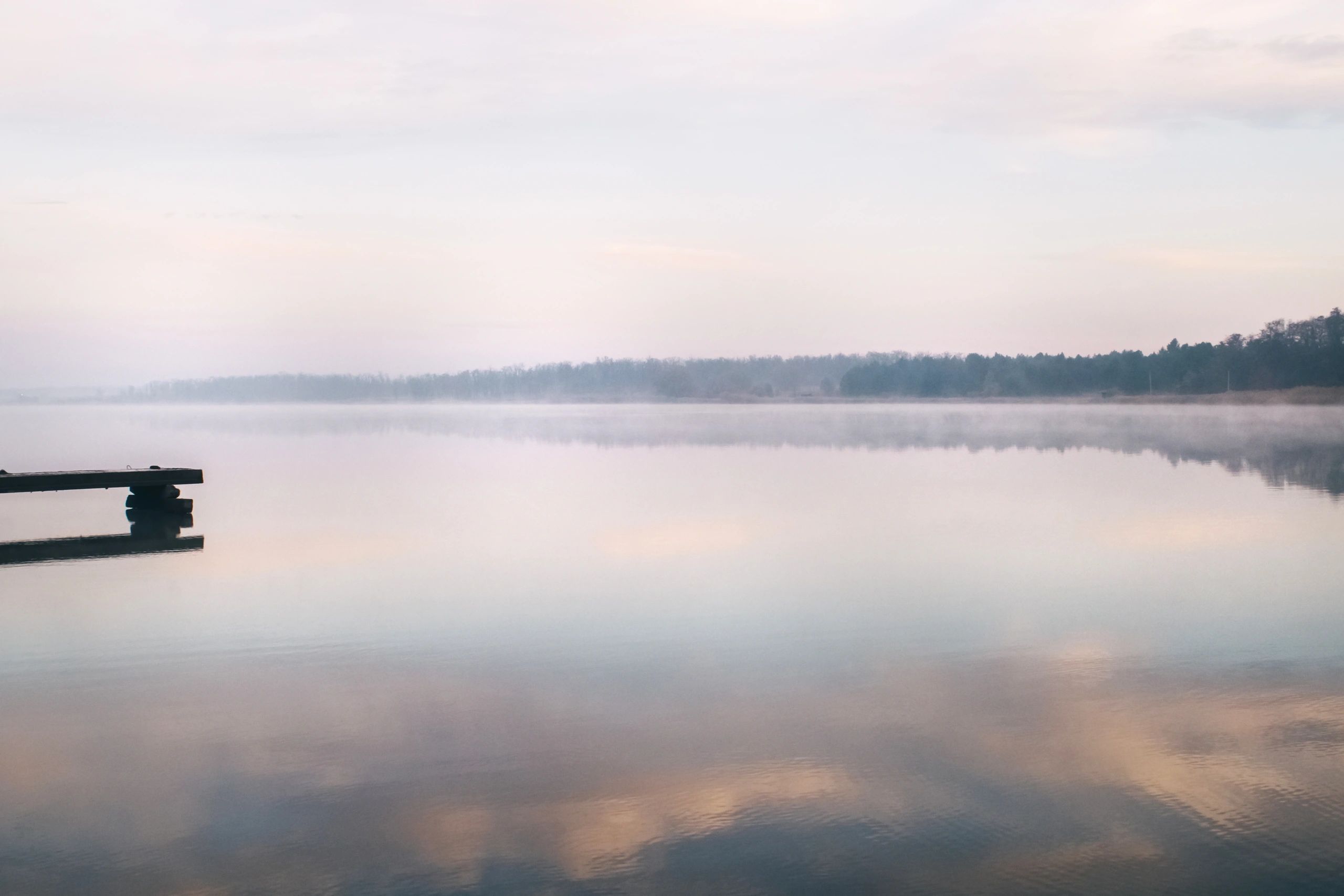 Fishing pier on a misty lake